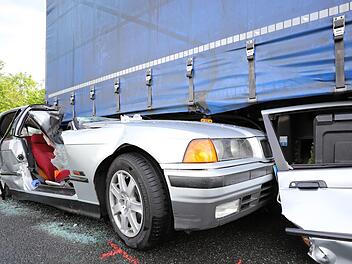 Fast die gesamte linke Seite des BMW wurde bei dem Unfall unter dem Lkw-Anhänger eingeklemmt. Foto: Marian Hamacher