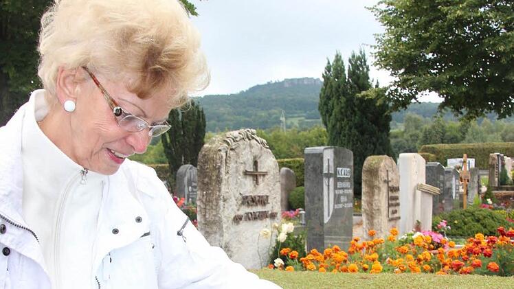 Marlis Thiele steht auf dem Friedhof in Bad Staffelstein an einer Buchsbaumhecke. So eine Hecke soll künftig auch das Feld mit den anonymen Urnengräbern umfassen. Foto: Giulia Schneider