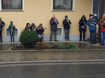 Eine der drei Musikgruppen der Musikvereinigung Ebensfeld flüchtete sich am Silvestertag bei Dauerregen unter die schützenden Dachvorsprünge eines Hauses. Kurz darauf brachen die Musiker das Spiel ab, weil sonst die hölzernen Instrumente beschädigt worden wären. Foto: Otto Weidner