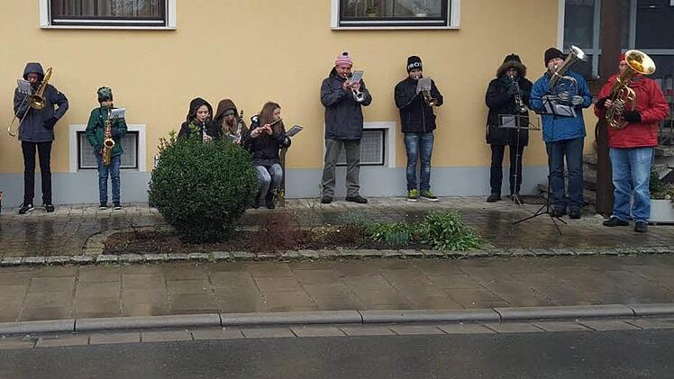 Eine der drei Musikgruppen der Musikvereinigung Ebensfeld flüchtete sich am Silvestertag bei Dauerregen unter die schützenden Dachvorsprünge eines Hauses. Kurz darauf brachen die Musiker das Spiel ab, weil sonst die hölzernen Instrumente beschädigt worden wären. Foto: Otto Weidner