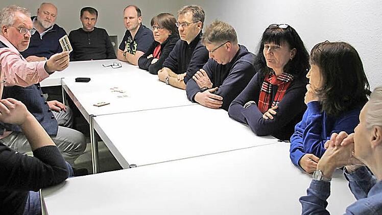 Karten gezeigt: Die Grundlagen des Schafkopfspiels erläutert Hans Forkel (Zweiter von links) am ersten Abend und präsentiert den Eichel-Zehner. Zum Teilnehmerkreis gehört auch einer, der seine Karten aktuell auch kräftig neu mischt: Michael Rahn aus Ebern, die neue rechte Hand von Landrat Wilhelm Schneider (Vierter von links), will künftig auch Trümpfe ausspielen. Foto: Ralf Kestel