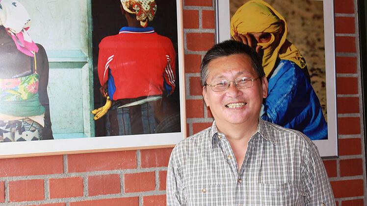 Kangping Piao vor zwei seiner Fotografien. Ein Lieblingsfoto hat er aber nicht. "Ich mag sie alle, sie haben alle eine besondere Bedeutung für mich." Foto: Katharina Becht