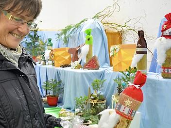 Publikumsmagnet beim Adventszauber in Waldfenster sind die selbstgemachten Deko-Artikel. Hier greift Elisabeth Wehner zu einem Weihnachtswichtel und einer Backmischung im Glas. Fotos: Kathrin Kupka-Hahn