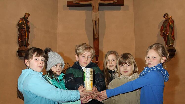 In der Modloser Kirche steht eine Kerze mit den Namen der Kommunionkindern.