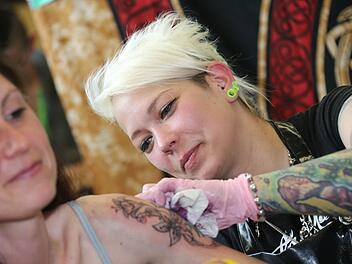 Konzentriert bei der Arbeit: Tätowiererin Punki, die in Strullendorf ein Tattoo-Studio betreibt. Foto: Matthias Hoch
