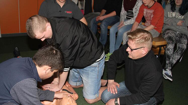 Uli Simon (im Hintergrund) und Frank Wilzok (vorne rechts) haben den Neuntklässlern der Stadtsteinacher Schule die wichtigsten Erste Hilfe-Leistungen beigebracht: Auch Reanimation und Beatmung standen auf dem Lehrplan. Foto: Sonja Adam