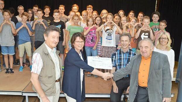 Mit einem symbolischen Scheck wurden 1000 Euro in der Realschule überreicht. Im Bild (vorne von links) Gerhard Burkert-Mazur, Schulleiterin Christa Bänisch, Konrektor Matthias Klinke, Heinz Hausmann, zweite Konrektorin Anja Schörner und dahinter die Klassensprecher  Foto: K.- H. Hofmann
