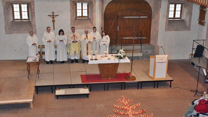 In der Abtei des Klosters Maria Bildhausen stand der sonntägliche Gottesdienst ganz im Zeichen der Euthanasieopfer. Für die 379 behinderten Menschen, der St. Josefskongregation, von denen acht aus Maria Bildhausen kamen, standen Kerzen vor dem Altar. Foto: Hanns Friedrich