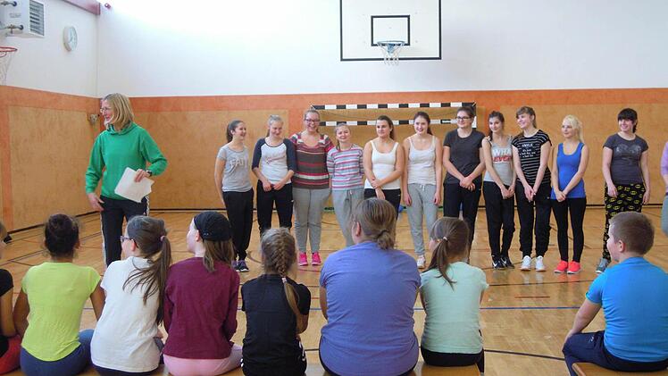 Elke Hausmann (links) stellt ihre noch etwas verhaltenen Sportschülerinnen (im Hintergrund) den Grundschülern vor. Foto: Julia Raab