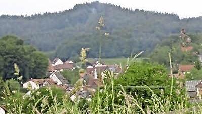 Links neben der Kirche ragt der Rest des Burgfelsens empor.