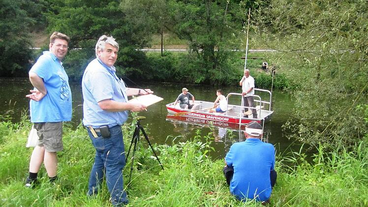 Eine Feuerwehrübung nutzten die Gräfendorfer Bürgermeister Johannes Wagenpfahl (links) und Alfred Frank (im Boot mit Messlatte), um Ingenieur Erich Hutzelmann Daten für den geplanten Radweg zwischen Gräfendorf und Michelau zu liefern. Foto: Wolfgang Schelbert