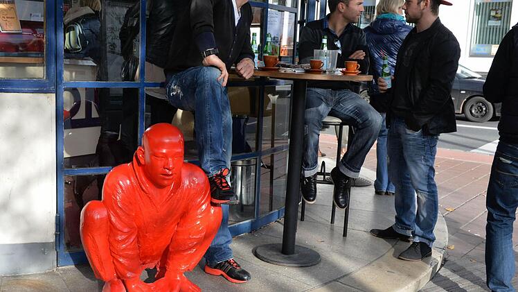 Am Schönleinsplatz sind die "roten Männer" verschwunden. Am nahen Cafe Rondo tauchte mittags einer als Bronze-Abguss auf. Alle Fotos: Ronald Rinklef