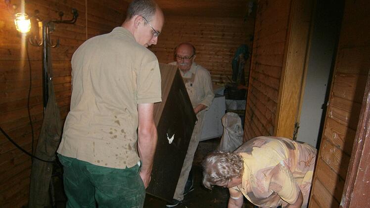 Nach dem Hochwasser 2014 räumt Hermann Kastner mit seiner Frau Gerlinde (rechts) und  seinem Neffen  Johannes Wurster (vorne)  auf. Wer bezahlt  den  Schaden?  Dazu läuft ein Rechtsstreit mit der Gemeinde Neuenmarkt. Foto: Archiv/Jürgen Gärtner
