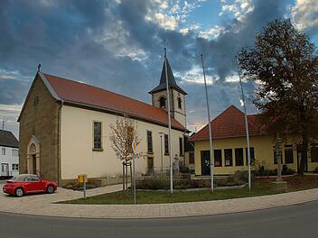 Der Kiliansplatz ist zum echten Schmuckstück des Stadtteils Seubrigshausen  geworden. Links auf dem Bild die Pfarrkirche St. Anna, rechts das Gebäude  der ehemaligen Raiffeisenbank, das heute der Stadt gehört und die Feuerwehr  beherbergt.