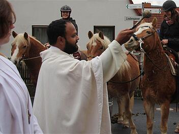Kaplan Murphy besprengt Reiter und Pferde mit Weihwasser.Fotos: Gerd Schaar