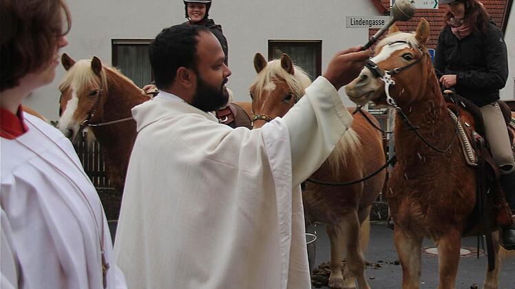Kaplan Murphy besprengt Reiter und Pferde mit Weihwasser.Fotos: Gerd Schaar