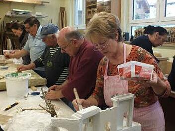 Marianne Baer von den Herzogenuracher Krippenfreunden  grundiert die Krippe, Beim tag der offenen Tür in der alten Haundorfer Schule hatten die Bastler viel zu erklären. Foto: Manfred Welker