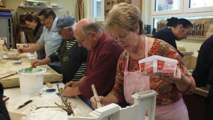 Marianne Baer von den Herzogenuracher Krippenfreunden  grundiert die Krippe, Beim tag der offenen Tür in der alten Haundorfer Schule hatten die Bastler viel zu erklären. Foto: Manfred Welker