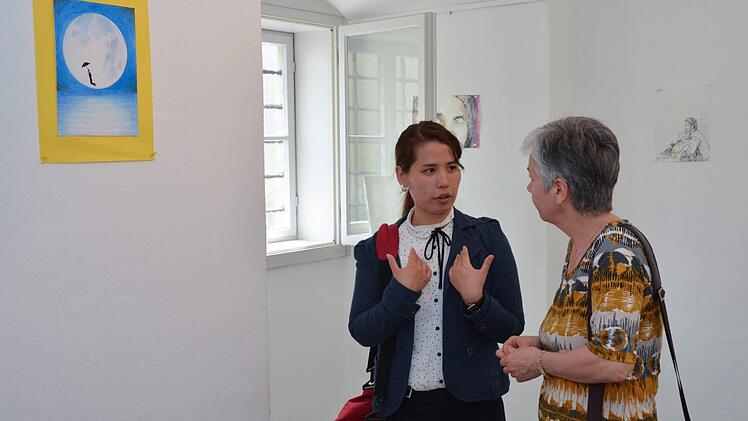 Golnessa Youseffi, die gemeinsam mit anderen Künstlern in den Galerieräumen des Deutschordensschlosses ausstellt, diskutiert mit einer Besucherin. Foto: Björn Hein