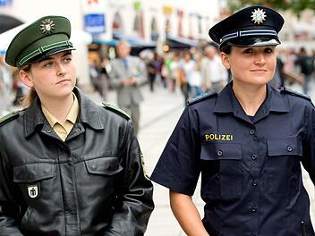 Zwei Polizeibeamtinnen präsentieren am 31.07.2014 in München (Bayern) im Rahmen einer Pressekonferenz das neue (r) und alte (l) Uniformkonzept der bayerischen Polizei. Ab August 2014 tragen zunächst etwa 500 Polizistinnen und Polizisten in einem Trageversuch die neue Dienstkleidung. Foto: Sven Hoppe/dpa