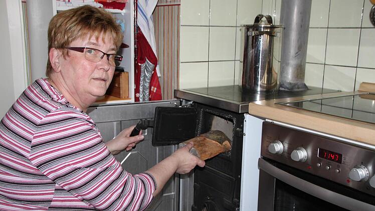 Für Doris Huber, Mieterin der Bad Brückenauer Baugenossenschaft, ist das Heizen mit Holz selbstverständlich. Fotos: Ulrike Müller