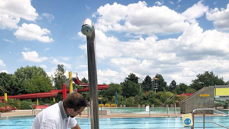 Ein Mitarbeiter des Freibads Hallstadt desinfiziert die Duschen.