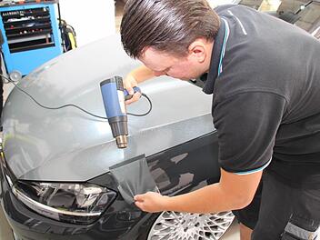 Mit handwerklichen Fähigkeiten und Fachwissen gelingt André Weber die Autofolierung. Foto: Matthias Beetz