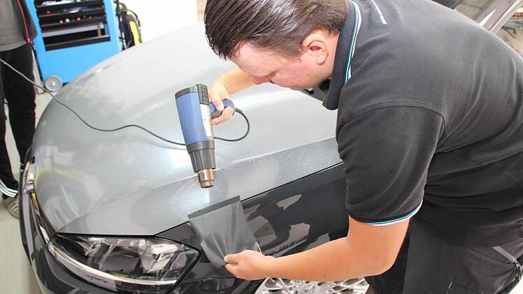 Mit handwerklichen Fähigkeiten und Fachwissen gelingt André Weber die Autofolierung. Foto: Matthias Beetz