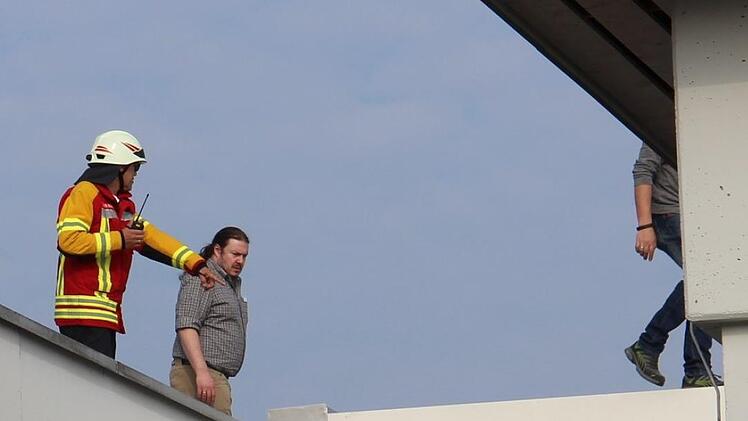Auf dem Dach: Kreisbrandinspektor Siegfried Zillig sucht mit Mitarbeitern nach Möglichkeiten, den Rauch aus dem Gebäude zu leiten.  Foto: Katharina Müller-Sanke