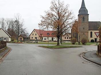 An der Einmündung des Dorfangers zum Dorfplatz wird die Verkehrsinsel entfallen. Dieser unübersichtliche Bereich wird neu gestaltet. Für den Baum, der gefällt werden muss, versprach Landrat Christian Meißner, an anderer Stelle drei neue Bäume zu pflanzen. Fotos: Matthias Einwag