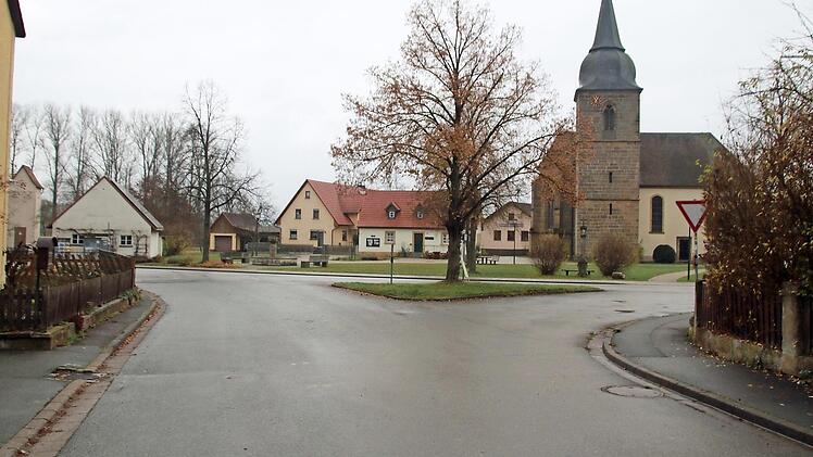 An der Einmündung des Dorfangers zum Dorfplatz wird die Verkehrsinsel entfallen. Dieser unübersichtliche Bereich wird neu gestaltet. Für den Baum, der gefällt werden muss, versprach Landrat Christian Meißner, an anderer Stelle drei neue Bäume zu pflanzen. Fotos: Matthias Einwag
