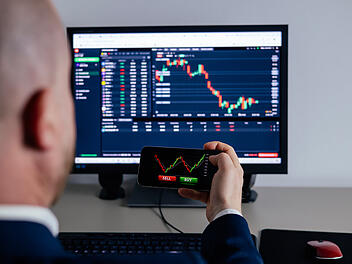 ETF B&ouml;rse Aktien Kurse Business man using a mobile device to trade stocks or currency on a financial market.  Nahaufnahme der Hand eines H&auml;ndlers, der ein Smartphone in der Hand h&auml;lt und eine Trading-App mit B&ouml;rsencharts zur Finanzanalyse und zur &Uuml;berwachung von Anlagedaten nutzt.