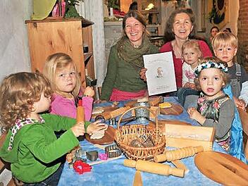 Das Kochbuch, das zum Jubiläum erstellt wurde, wird beim Fest am Sonntag, 28. Juni, verkauft. Unser Bild zeigt einige der Kinder mit der Köchin Sandra Schmitt (hinten links) und der Leiterin der Krippe im "Kinderhof Sonnenschein", Ulrike Brandl.  Foto: Ulrike Langer