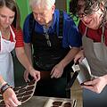 Franziska Böhner (links) und Petra Griebel (rechts) lassen sich von Hans-Dieter Herold Tipps geben, wie die Butterbrote garantiert gelingen. Foto: Sonny Adam