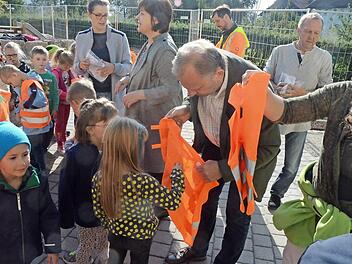 Die Warnwesten waren Objekt der Begierde bei den Erstklässlern. Bernhard Schmitt hatte alle Hände voll zu tun.  Foto: K.- H. Hofmann