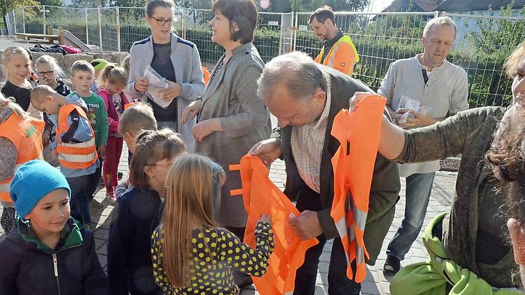 Die Warnwesten waren Objekt der Begierde bei den Erstklässlern. Bernhard Schmitt hatte alle Hände voll zu tun.  Foto: K.- H. Hofmann