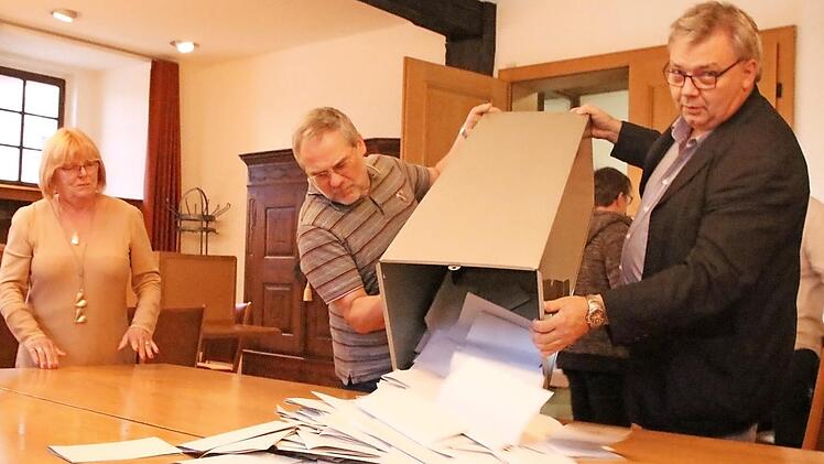 Die Wahlhelfer Christl Pottler, Dietmar Herrnleben und Anton Aumüller (von links) in Zeil leeren kurz nach Schließung der Wahllokale am Wahl-Sonntag um 18 Uhr den Behälter mit den Stimmzetteln aus. Kurz darauf beginnt die Stimmzählung. Foto: Andreas Lösch