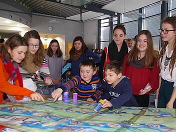 Die Lesepaten (von links): Frederike Fischer, Lea-Sophia Friedlein, Franziska Maurer, Sophia Weiß und Hanna Ponsel, die Seminar-Teilnehmerinnen Katharina Abad Borger und Sophia Kraus sowie (vorne, von links): die Zweitklässler Lisa, Daniel und Tarek beim gemeinsamen Lese-Lern-Spiel  Foto: Heike Schülein