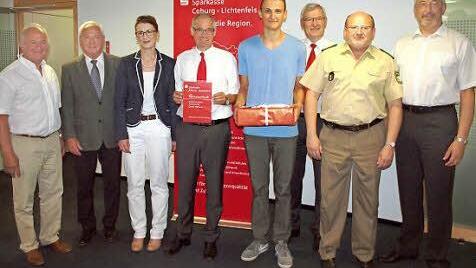 F Gewinnübergabe eines Bausparvertrages mit einer Einlage von 600 Euro, von links: Alfons Hrubesch, Vorsitzender der Kreisverkehrswacht, Landratstellvertreter Helmut Fischer, Marion Merz (LBS Oberfranken), Sparkassendirektor Roland Vogel, Gewinner Fabian Fischer, Walter Partheymüller von der Sparkasse, Polizeiinspektionsleiter Willibert Lankes und Bezirksvorsitzender Udo Skrzypczak.  Foto: Alfred Thieret