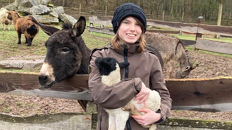 Samira Kempf aus Bad Bocklet ist im Park als Tierpflegerin beschäftigt. Das kleine Rhönschaf, das sie im Arm hält, hat noch keinen Namen. Für das Tier können Tierfreunde eine Patenschaft übernehmen.Foto: Charlotte Wittnebel-Schmitz