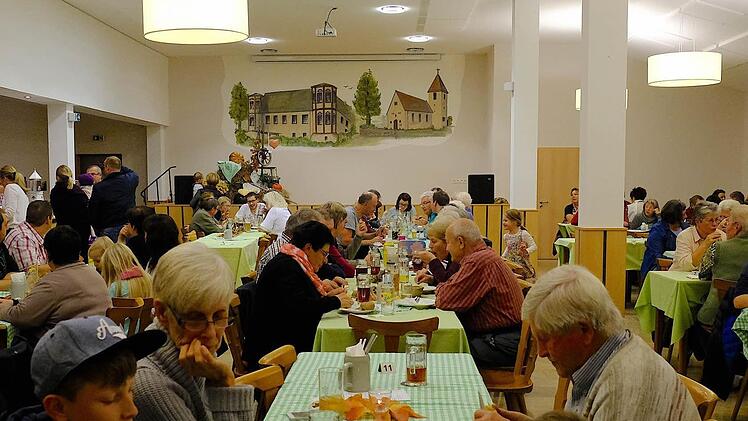 Die freien Plätze im Saal waren bald Mangelware. Froh ist man über das Gemälde (im Hintergrund), das Gottfried Schimetschek nach der Innenrenovierung wieder neu auf die Bühnenwand malte. Foto: Gerd Schaar
