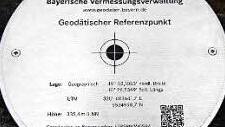 Diese auf einem kniehohen Findling montierte Edelstahlscheibe ist das Herzstück des Geodätischen Referenzpunktes am Steigerwald-Zentrum in Handthal. Hier sind zum Abgleich mit GPS-Empfänger oder Smartphone die genauen Koordinaten hinterlegt. Foto: Norbert Vollmann