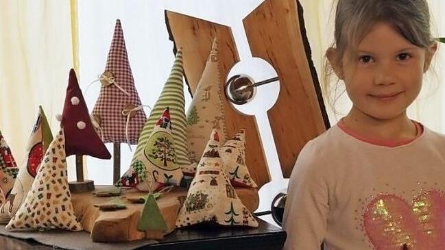 Johanna König hat die Weihnachtsbäumchen alle selbst genäht (Bild links). Ihre Ausstellung ist im Stand der "Wanderhühner" in Bad Staffelstein zu sehen (Bild rechts). Fotos: Monika Schütz