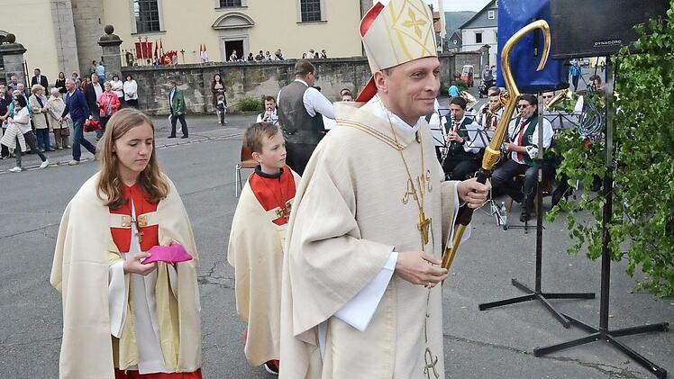 Weihbischof und Festprediger Herwig Gössl mit Ministranten auf dem Weg zum Altar. Im Hintergrund rechts der Musikverein Glosberg