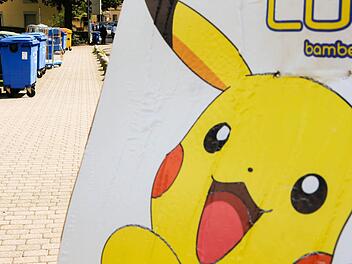 Ein gelbes Pokémon-Plakat vor der Tourist-Info in der Geyerswörthstraße. Im Hintergrund steht der Müll zu Abholung bereit.  Foto: Matthias Hoch