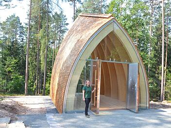 Friederike Reuß steht an der schweren Eingangstür des neuen Andachtsraumes im Ruhewald Schloss Tambach. Foto: Rainer Lutz