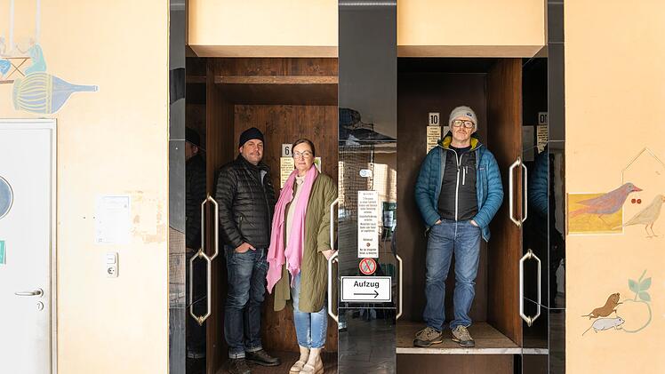 Kira Weißbach, Chefin des Großmarkts, nimmt Sebastian Bezzel (links) und Simon Schwarz im Paternoster mit.