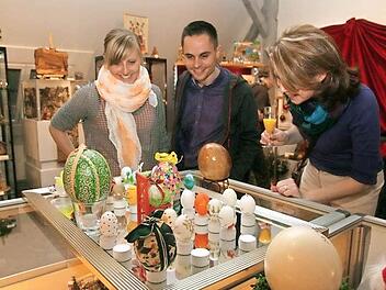 Betrachter amüsieren sich angesichts des beziehungsreichen Eier-Sortiments von Hirschaider Kommunalpolitikern.  Fotos: Werner Baier