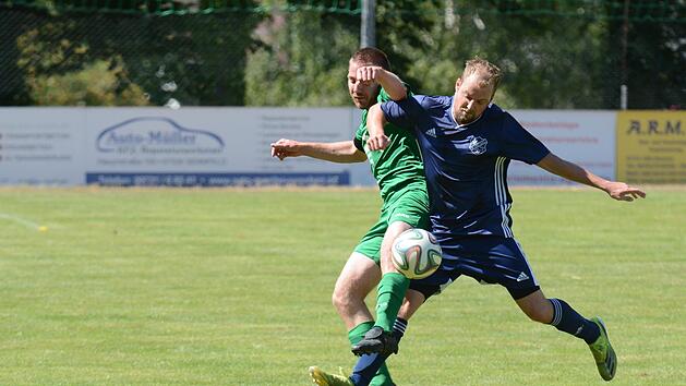Machtilshausens Christian Simon (gr&uuml;nes Trikot) hatte Auras F&uuml;hrungstreffer fix egalisiert, am Ende waren es aber doch Patrick Falkenstein (blaues Trikot) und seine Kollegen, die den Platz als Gewinner verlassen sollten. Foto: ssp