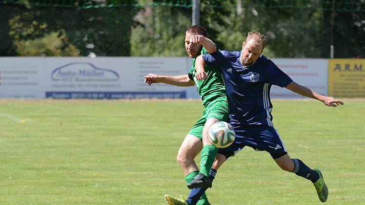 Machtilshausens Christian Simon (grünes Trikot) hatte Auras Führungstreffer fix egalisiert, am Ende waren es aber doch Patrick Falkenstein (blaues Trikot) und seine Kollegen, die den Platz als Gewinner verlassen sollten. Foto: ssp